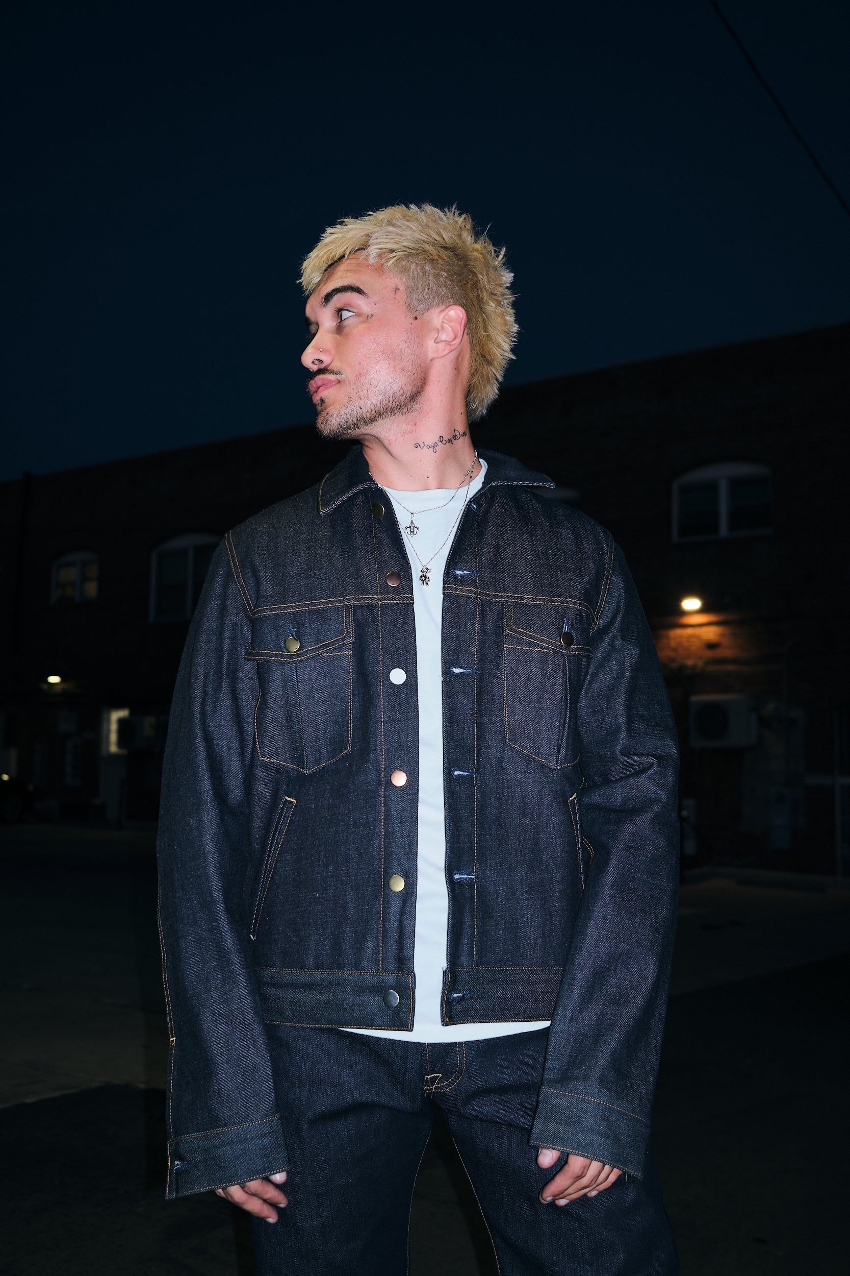 A Man Close Up Wearing Rope indigo raw denim trucker jacket with chest flap pockets and mixed metal buttons, front view