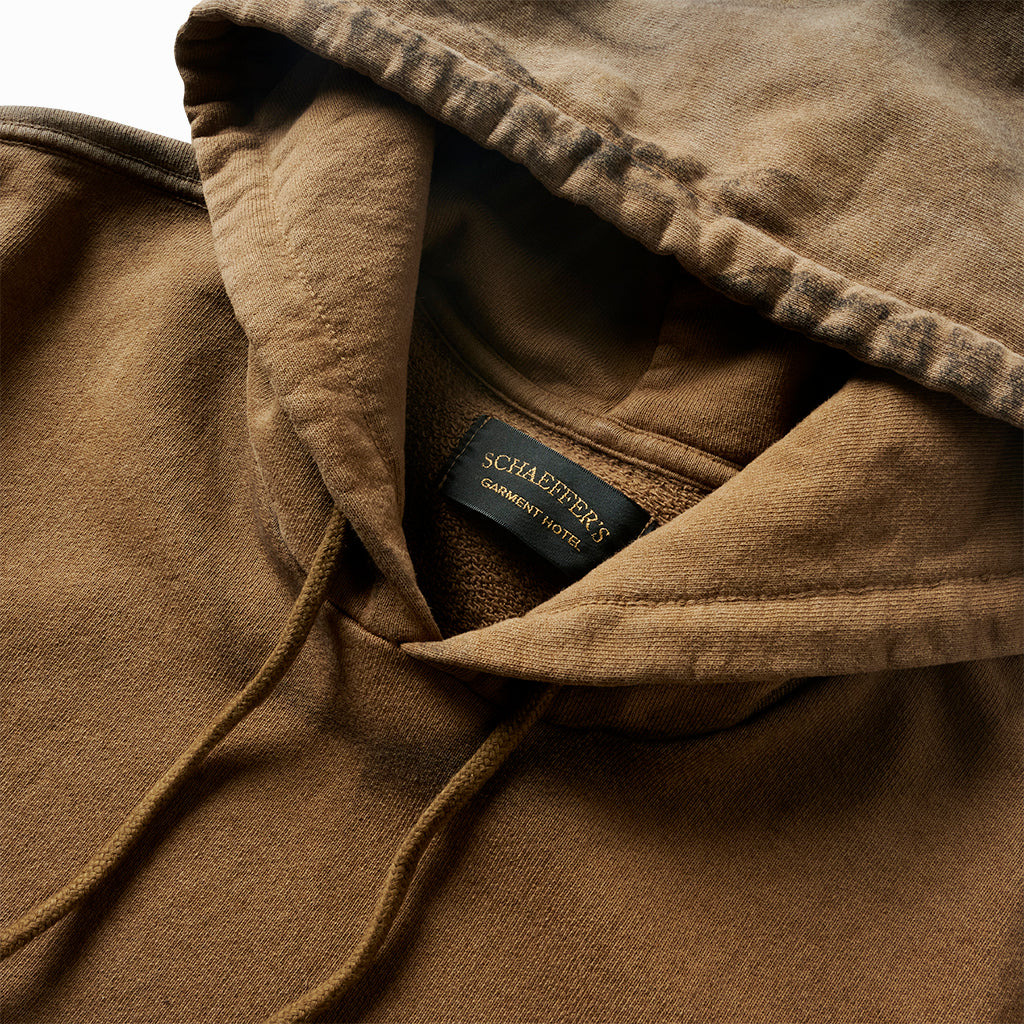 Close-up of the tan hoodie's hood, drawcords and Schaeffer's Garment Hotel neck label