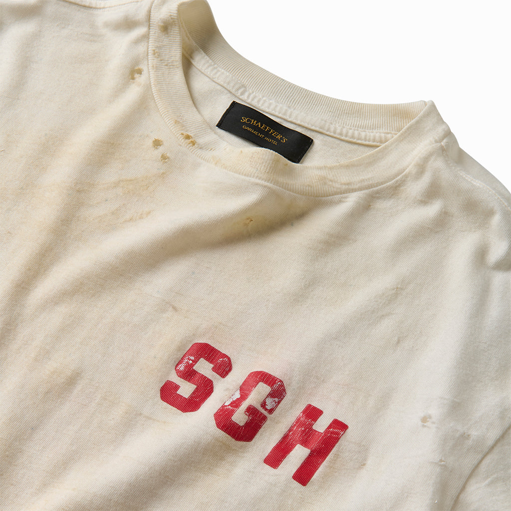 Close-up of the red SGH chest print and stained collar on the distressed white tee