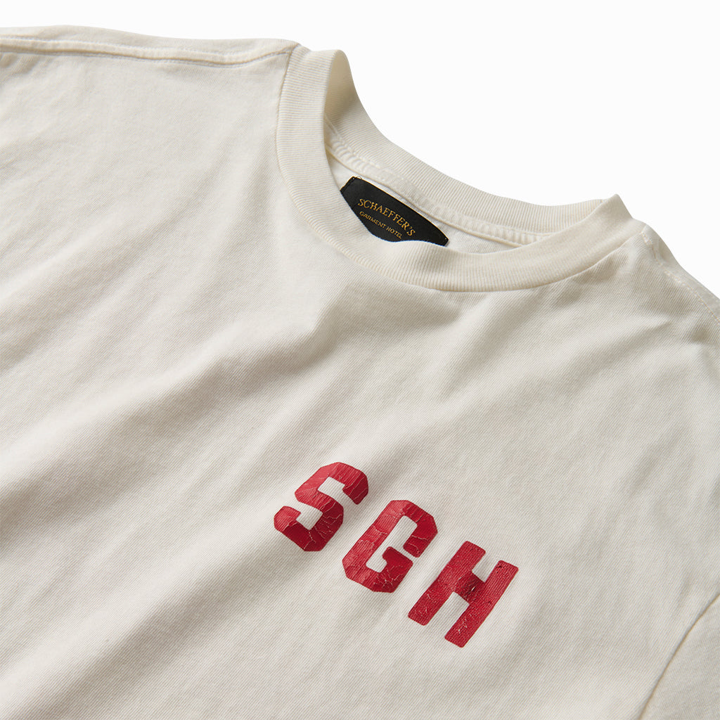Close-up of the red SGH chest print and collar label on the off-white tee