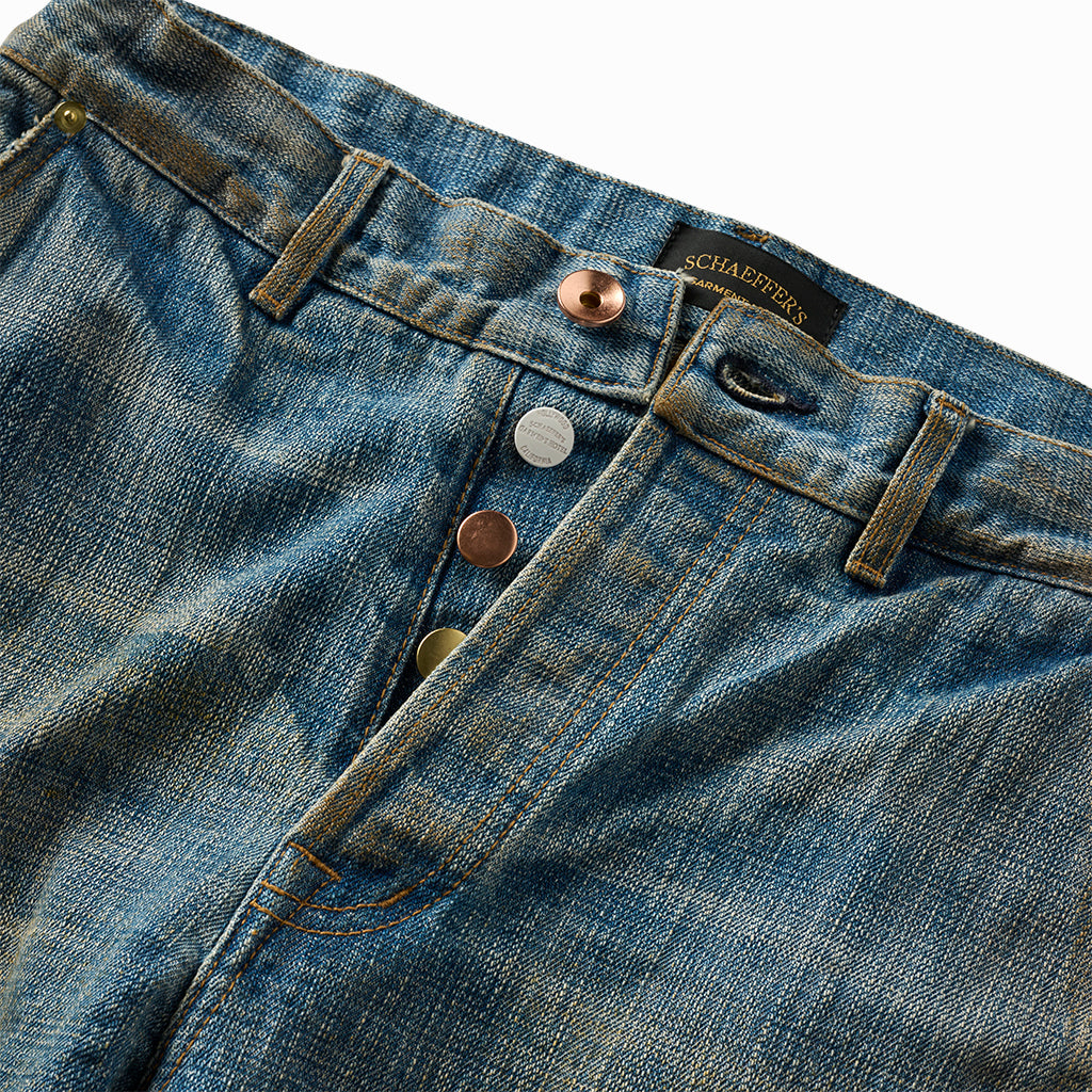 Close-up of the light indigo waistband with copper and silver button fly and Schaeffer's label