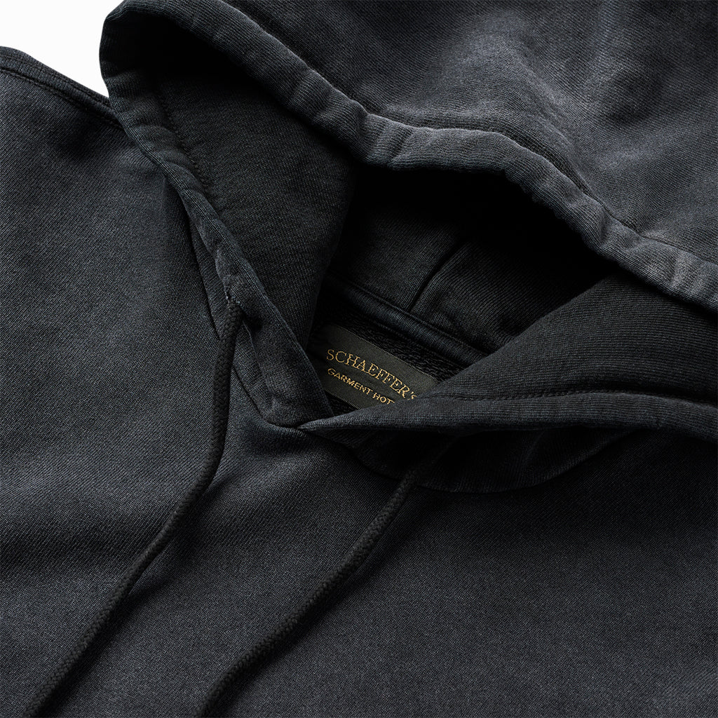 Close-up of the black hoodie's hood, drawcords and Schaeffer's neck label