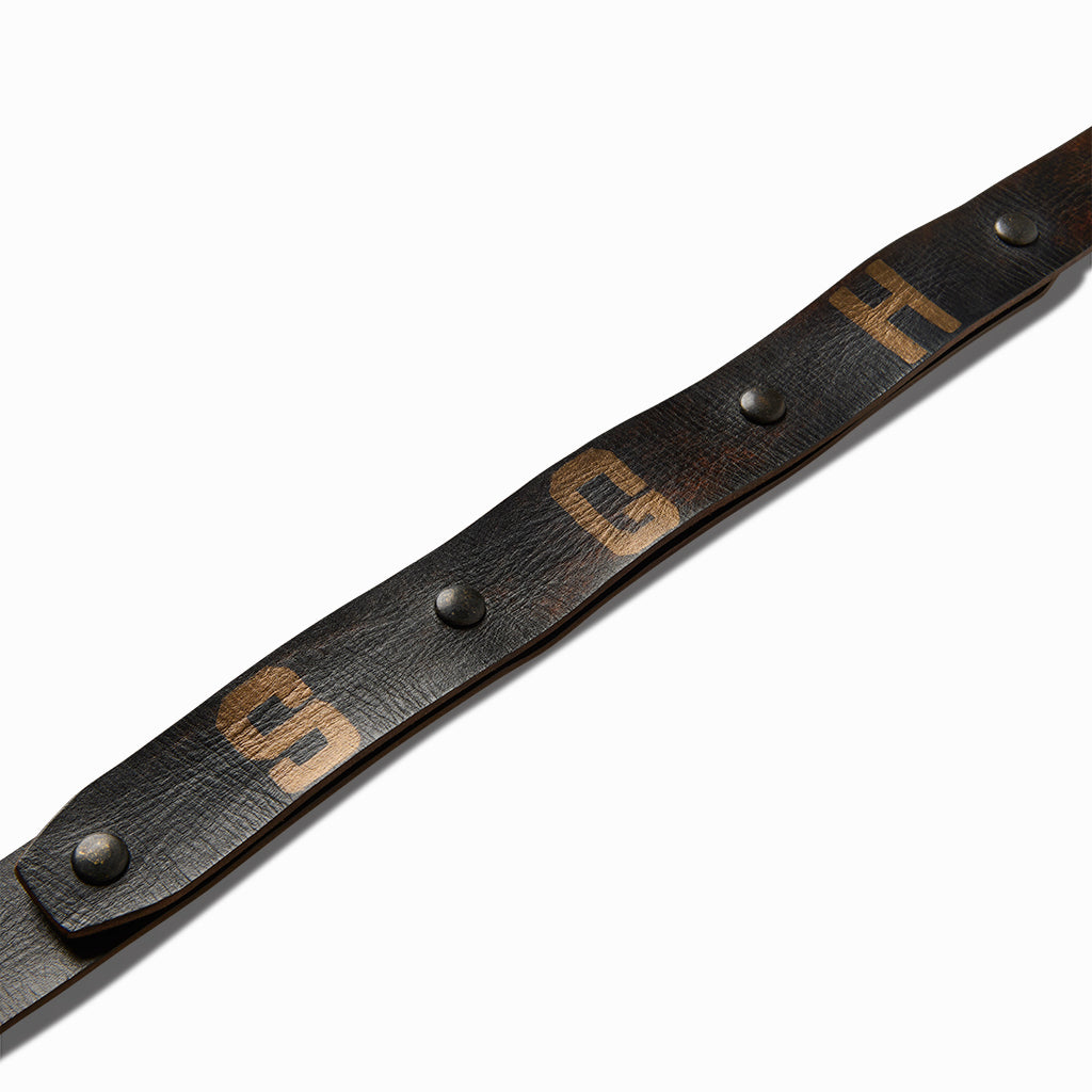 Close-up of the hand-painted S, G and H letters on the black leather belt