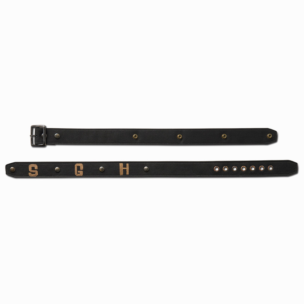Black SGH canvas belt laid flat in two pieces showing the studs and holes