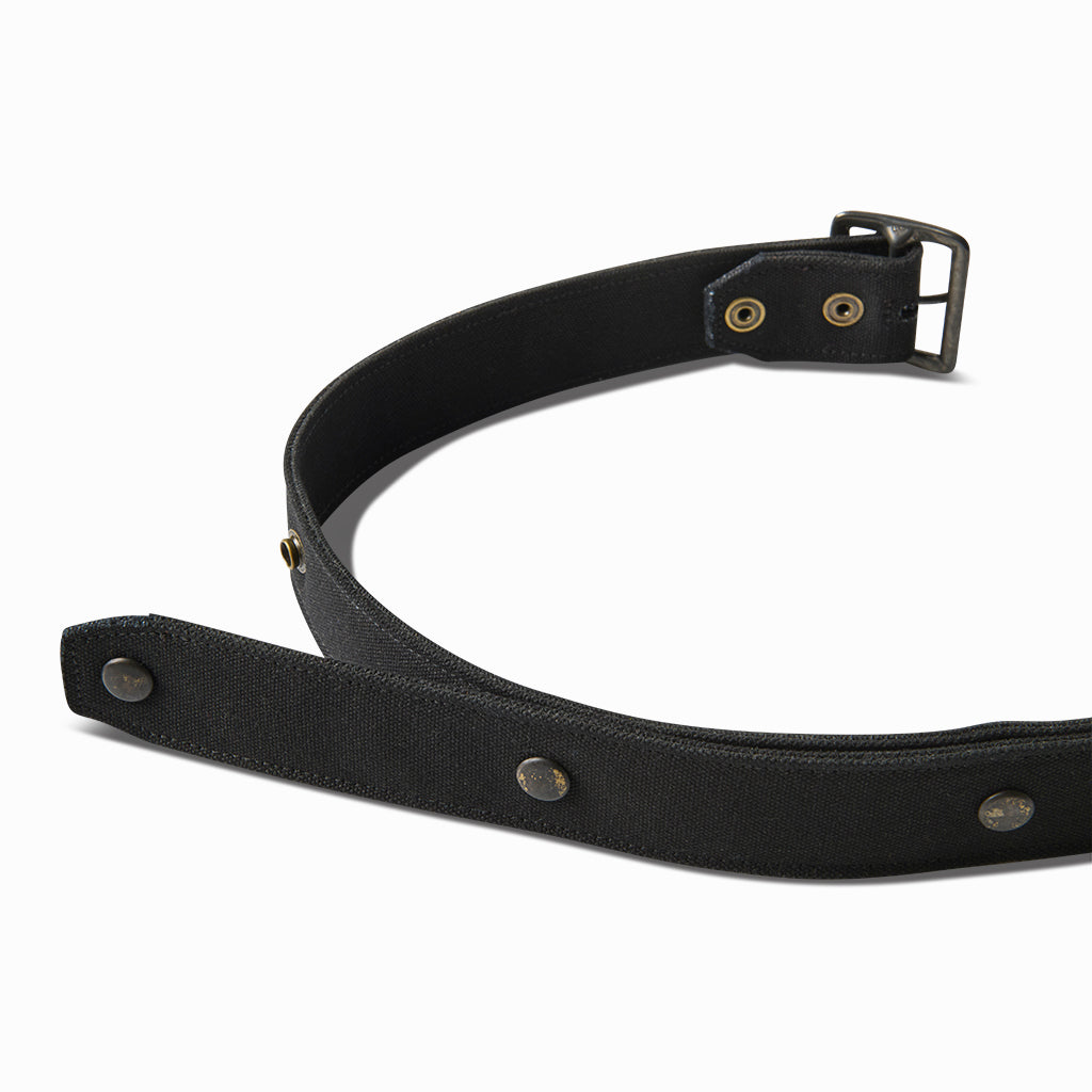 Black canvas grommet belt curved to show the buckle end and studs