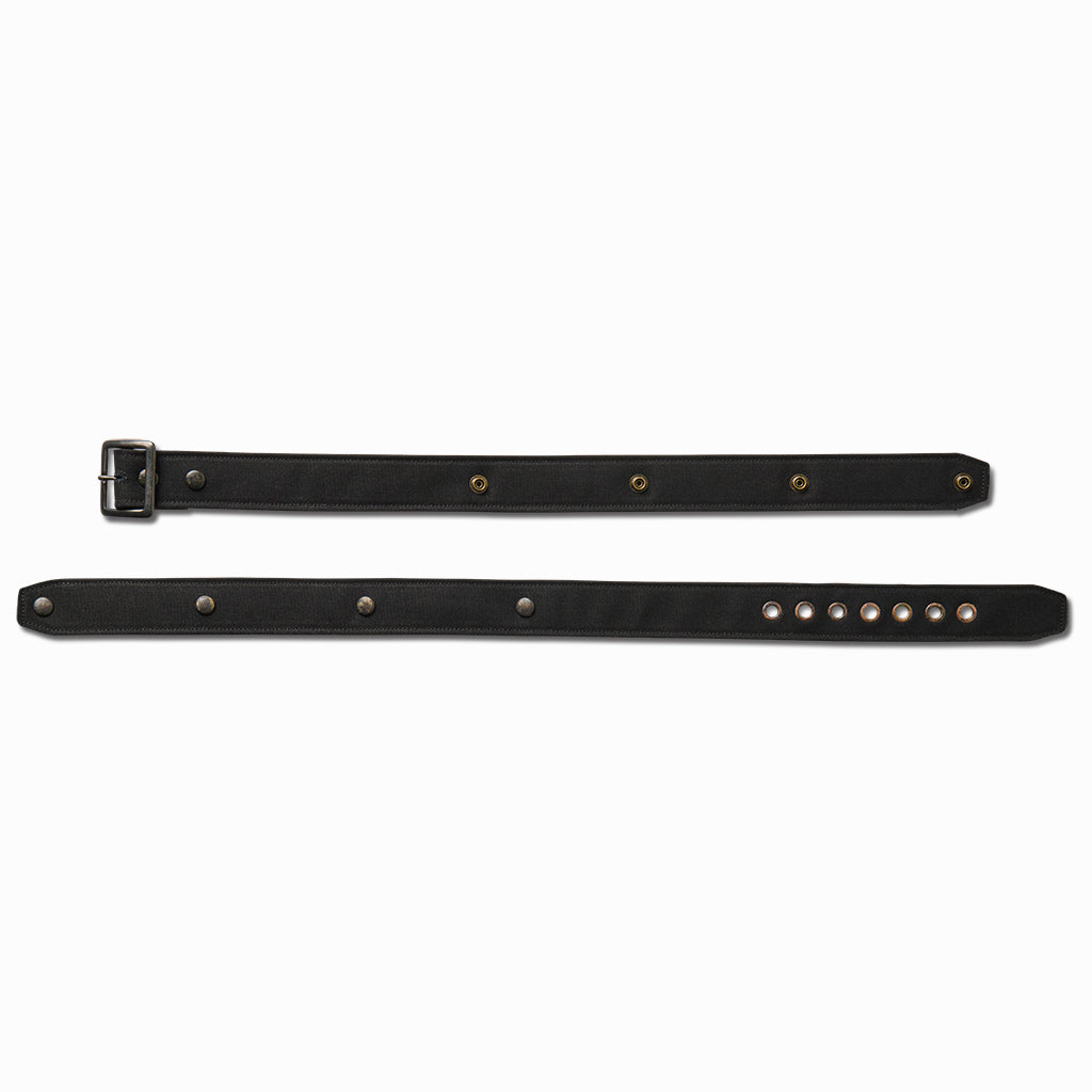Black canvas belt laid flat in two pieces showing the adjustment studs and holes
