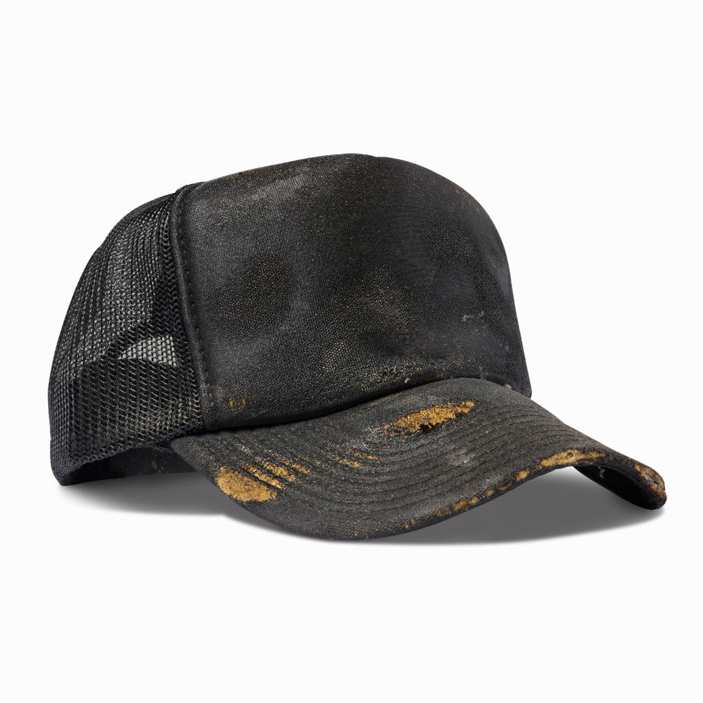 Oil-aged black trucker hat, angled view showing the mesh back