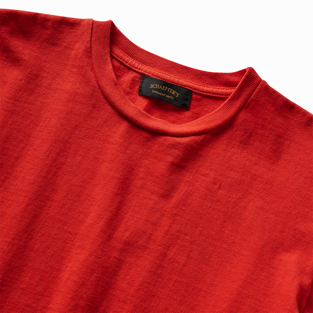 Close-up of the red athletic tee's ribbed collar and Schaeffer's neck label