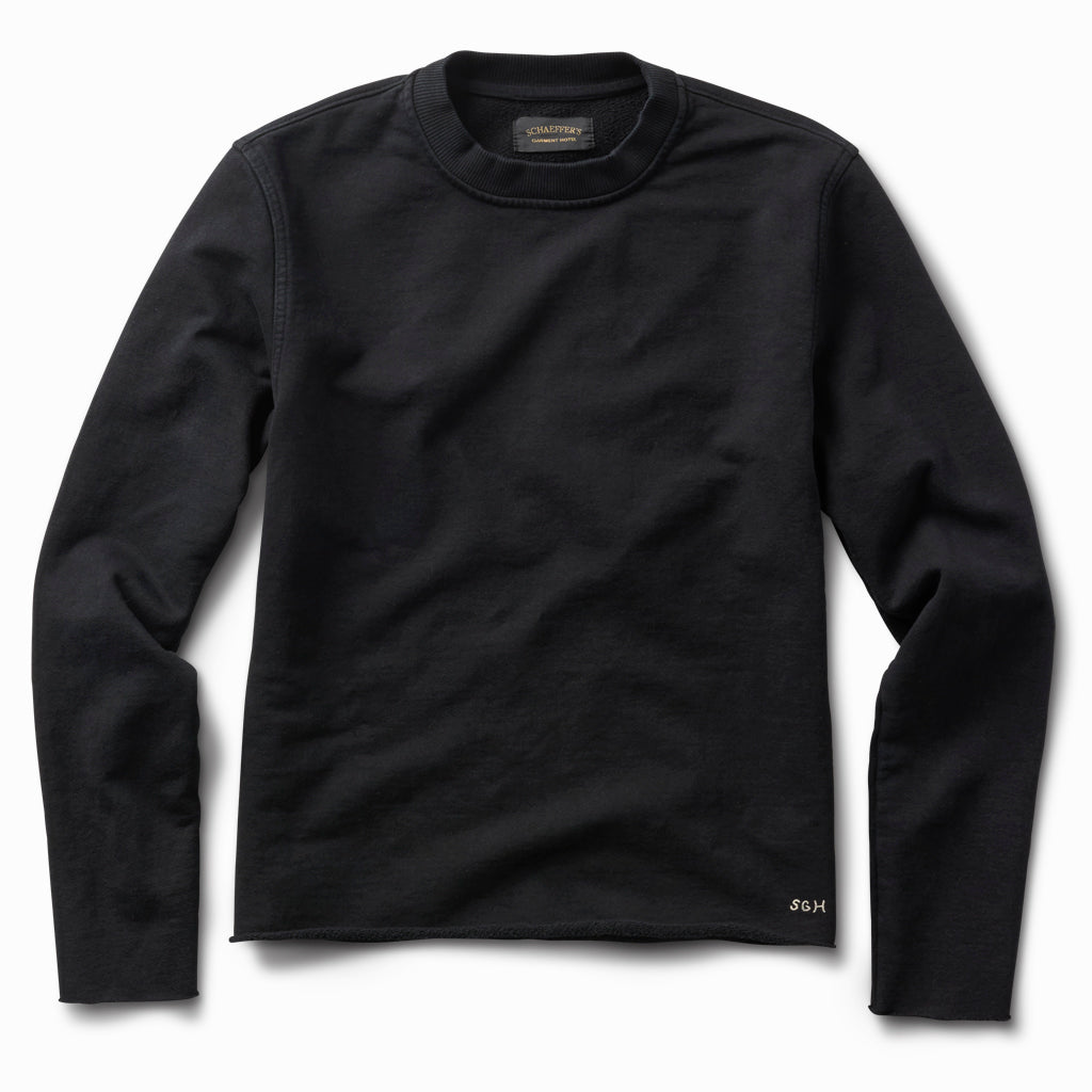 Washed black raw edge French terry crew sweatshirt, front view, with small SGH embroidery at the hem