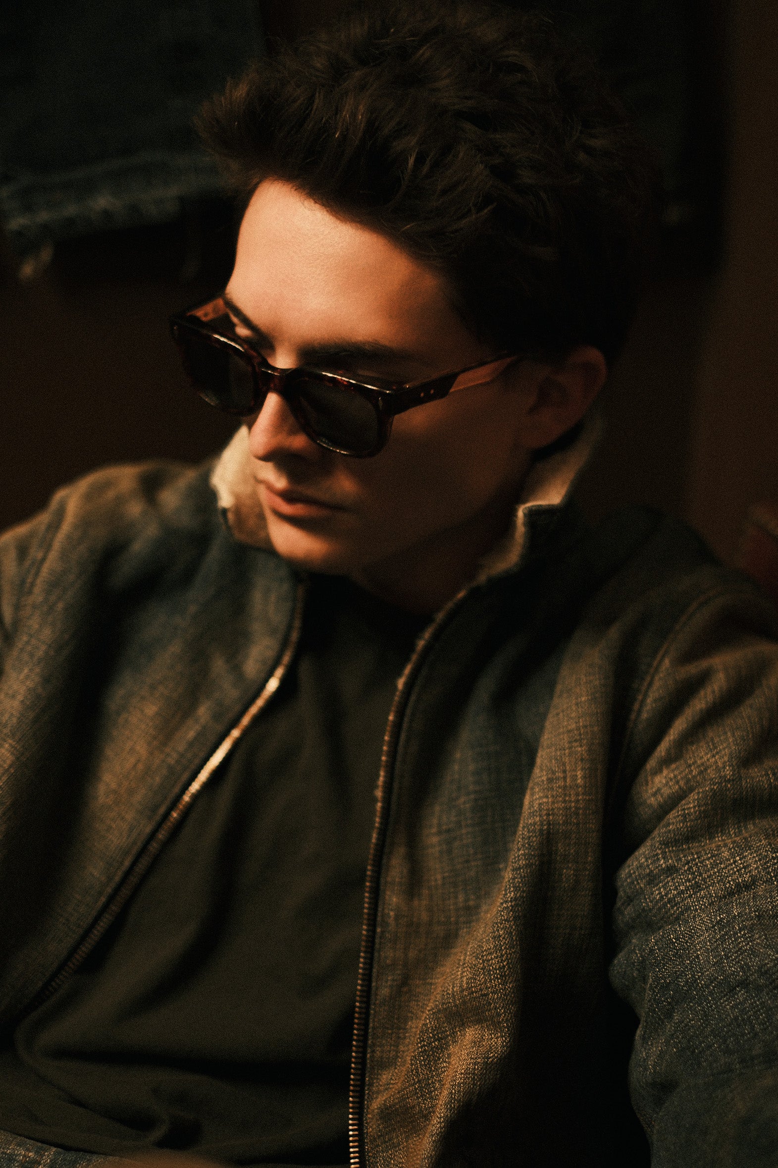 Close-up of a model in sunglasses wearing the destroyed shearling denim jacket