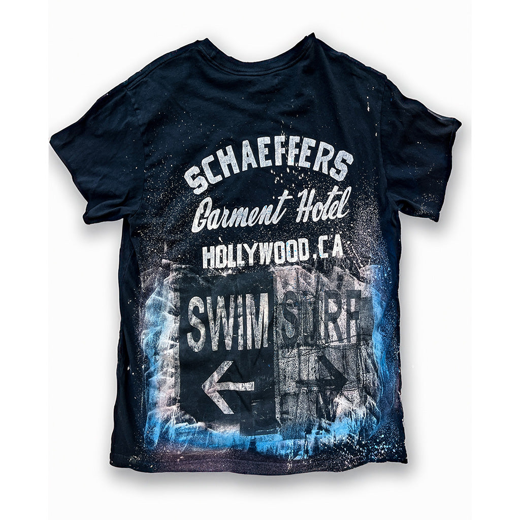 Back of the bleached navy tee with a Schaeffer's Garment Hotel Hollywood, CA Swim Surf graphic