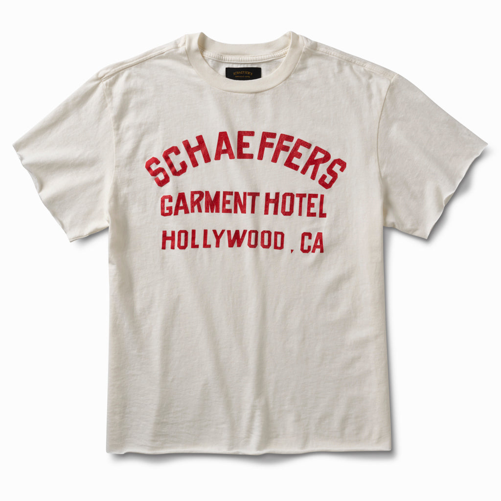 Off-white raw cut tee with a red Schaeffers Garment Hotel Hollywood, CA varsity print, front view