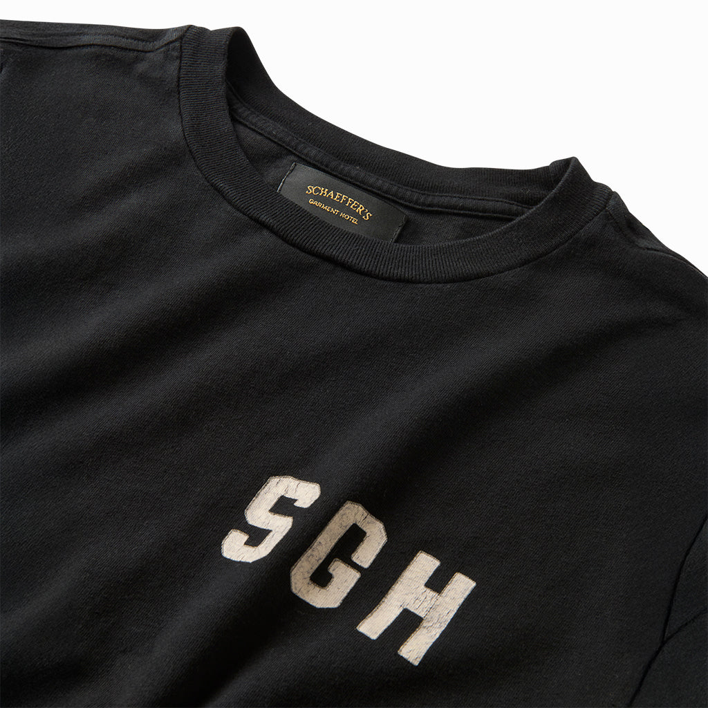 Close-up of the white SGH chest print and collar label on the black tee