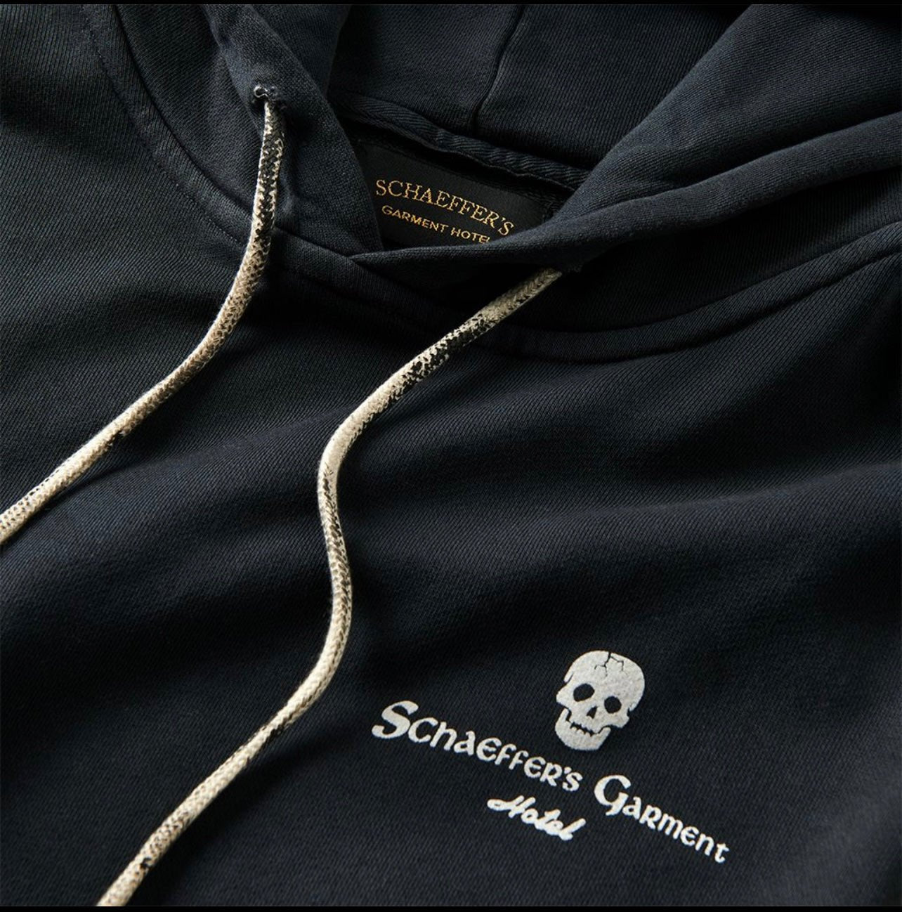 Close-up of the skull and Schaeffer's Garment script chest print and cream drawcords