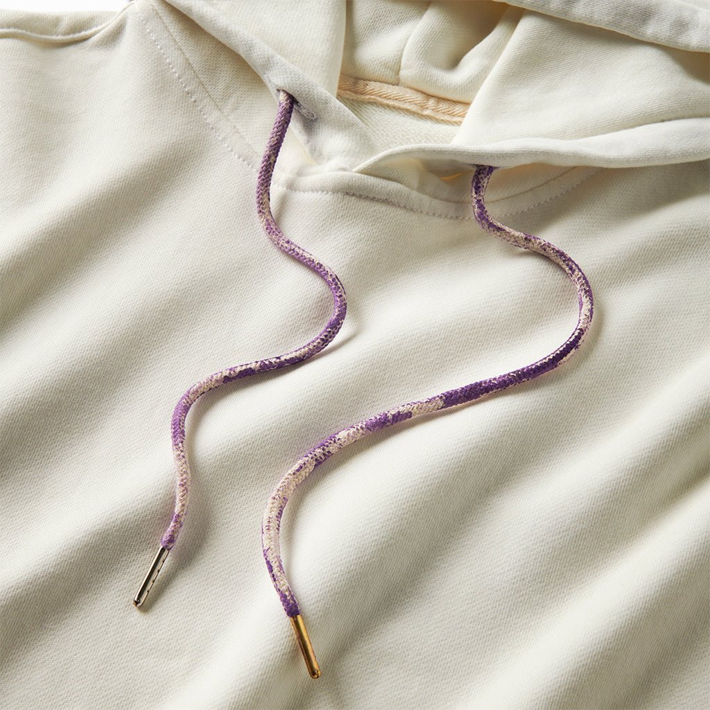 Close-up of the white hoodie's purple and cream drawcords with brass tips