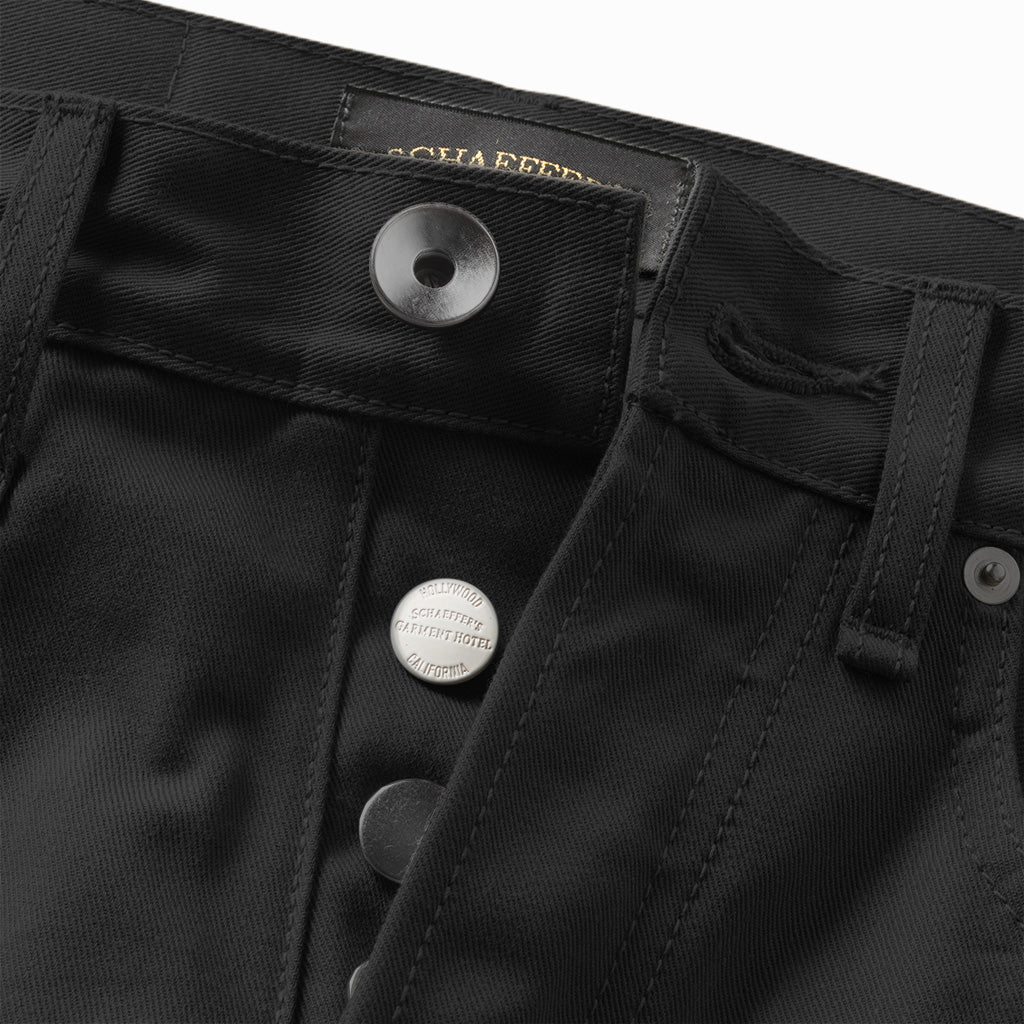 Close-up of the black jeans' silver button fly and Schaeffer's label