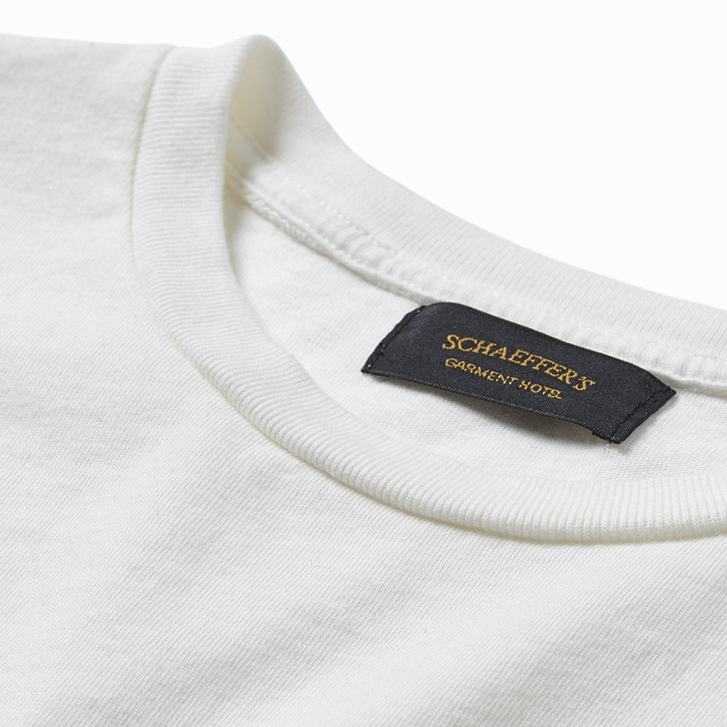 Close-up of the off-white pocket tee's ribbed collar and Schaeffer's Garment Hotel neck label