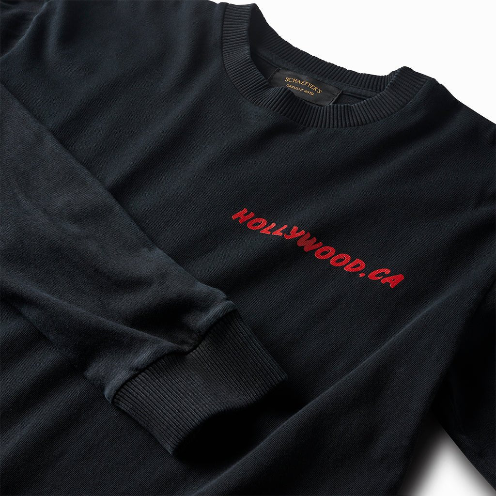 Close-up of the red Hollywood, CA chest print and ribbed cuff on the black long sleeve