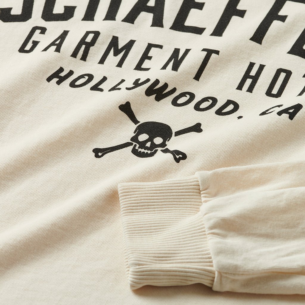 Close-up of the skull and crossbones print and ribbed cuff on the off-white long sleeve