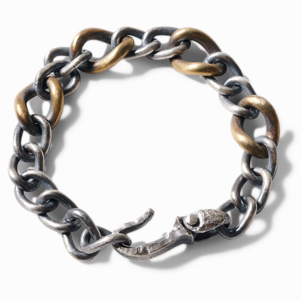 Chunky curb link bracelet mixing oxidized sterling silver and brass links, with a hook clasp