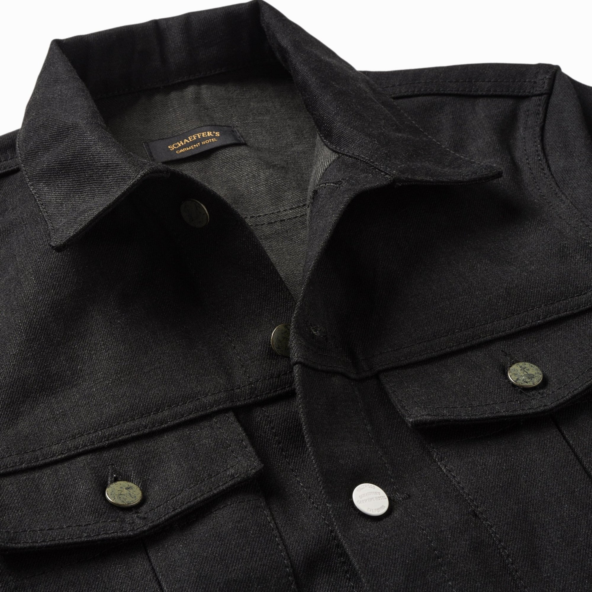 Close-up of the sulfur black jacket's collar, Schaeffer's label and snap buttons