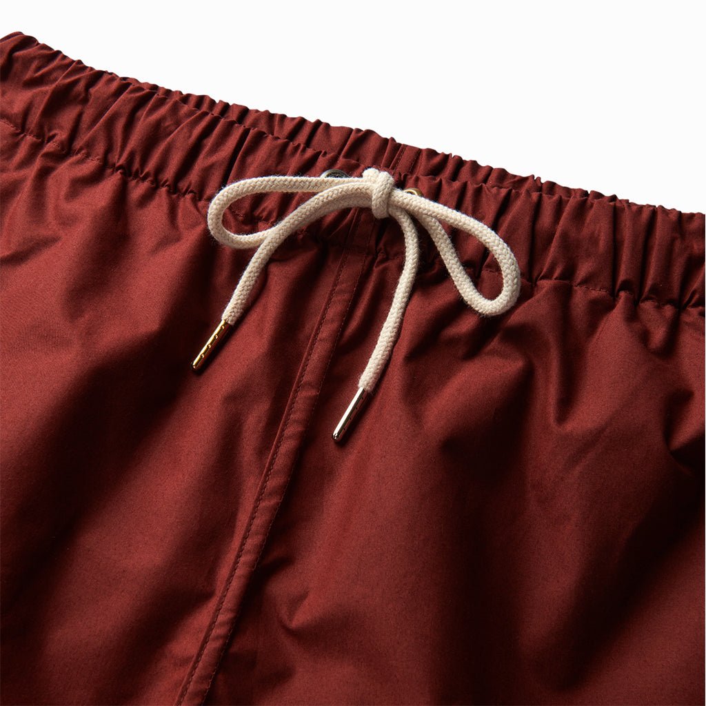Close-up of the ox blood trunks' elastic waist and cream drawcord