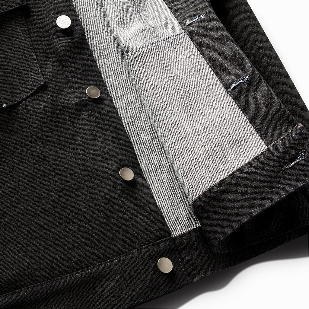 Close-up of the New Paloma jacket's snap buttons and grey selvedge inner placket
